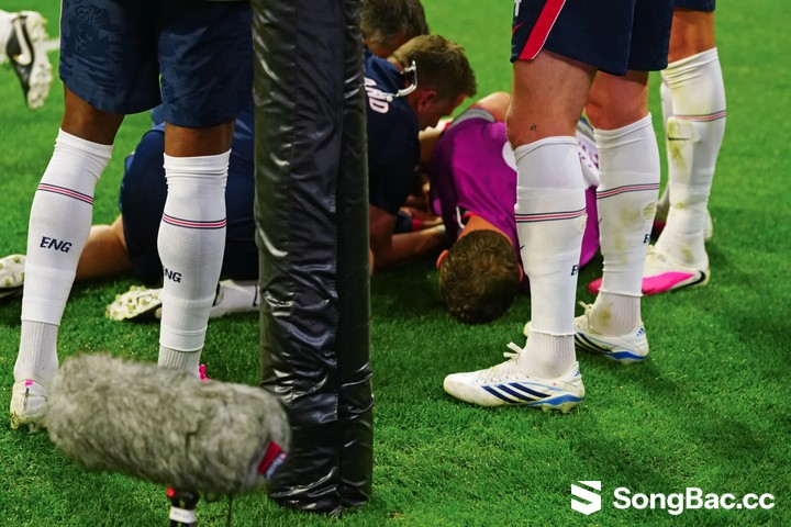 Jordan Henderson ngã xuống sân sau trèo qua biển quảng cáo. (Ảnh: The Sun)