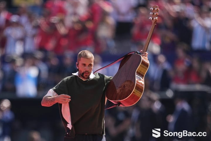 Justin Bieber vừa ôm guitar vừa trình bày phiên bản acoustic của "Everything Hallelujah". (Ảnh: AP)